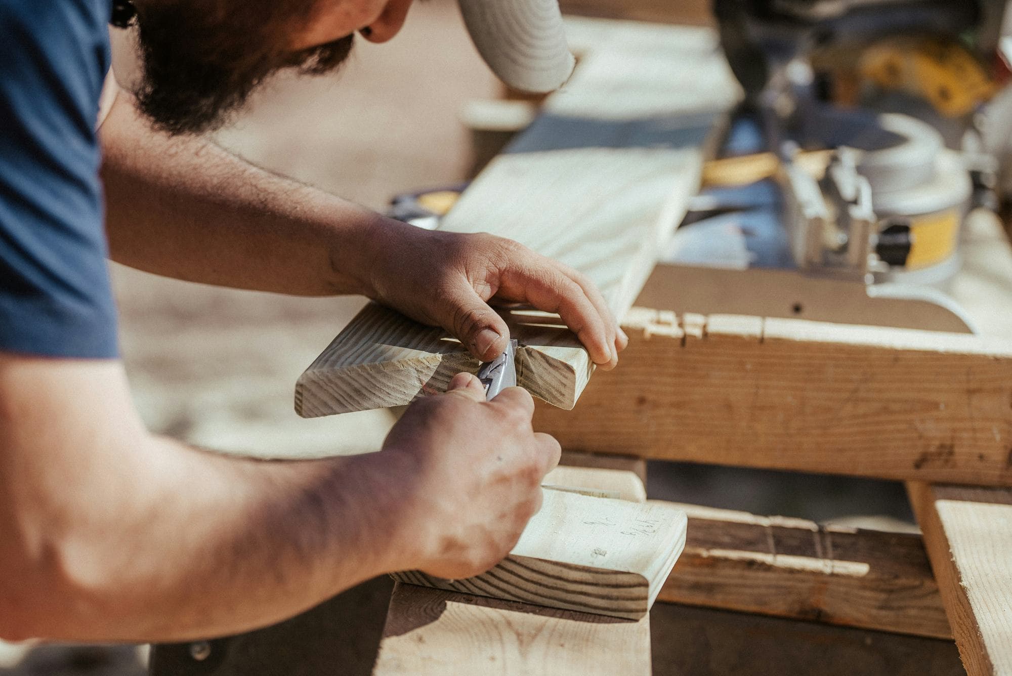 Carpenter marking a length of timber on a workbench